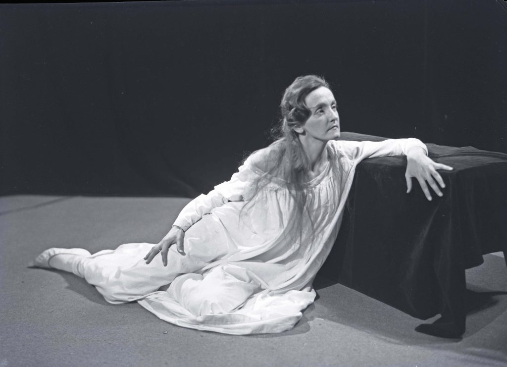 Actor sitting of floor in white dress | Joyce Williams as Lady Macbeth in sleepwalking scene. 1961. Hannan Photographic Archive [AHAN00471]