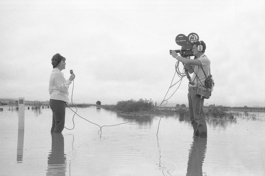 Barry Nancarrow on Camera filming NBN Reporter in Flood Waters (Courtesy of the NBN Archive)
